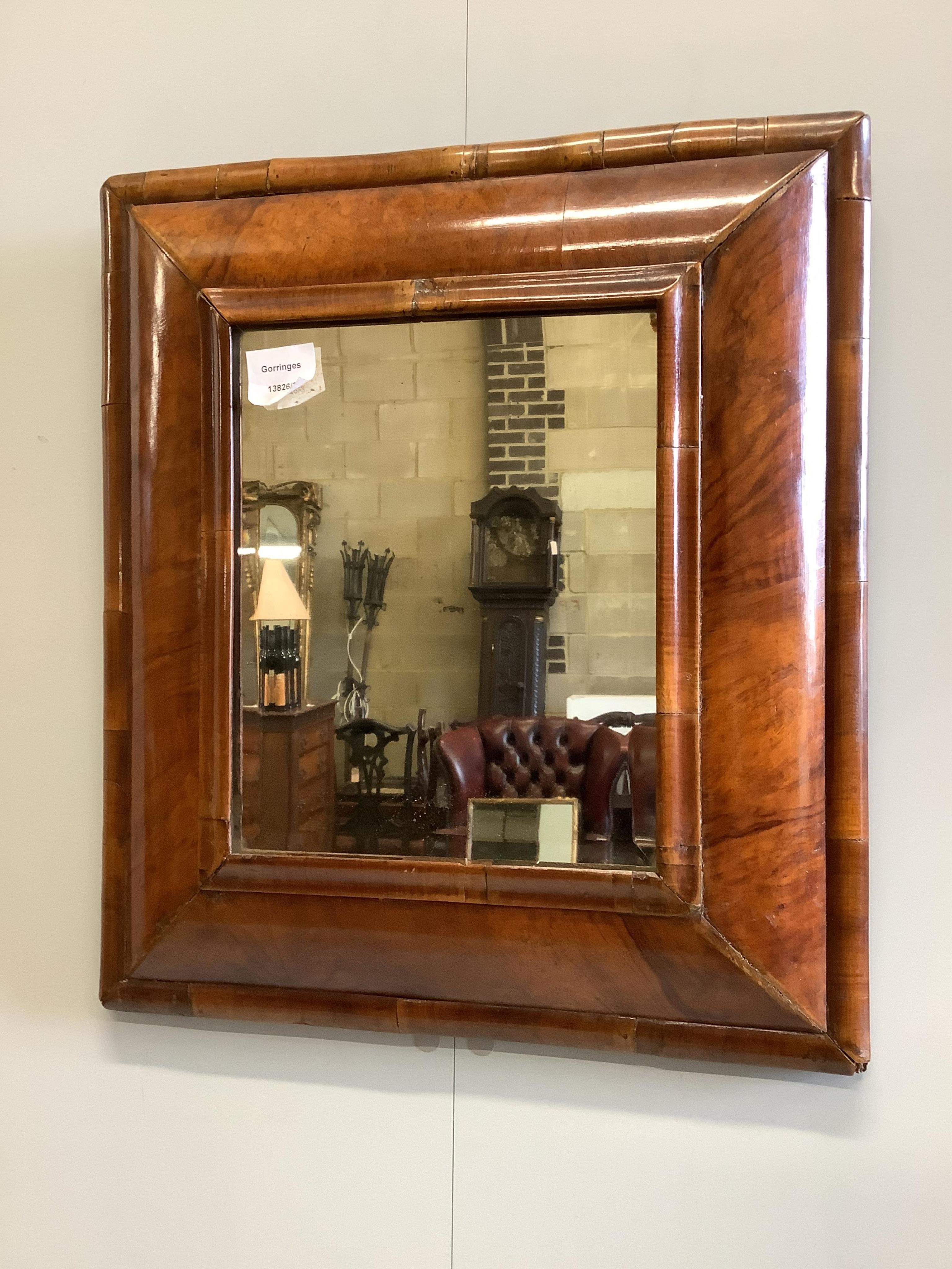 A walnut veneered cushion-framed wall mirror, in the William & Mary style, width 45cm, height 50cm. Condition - fair